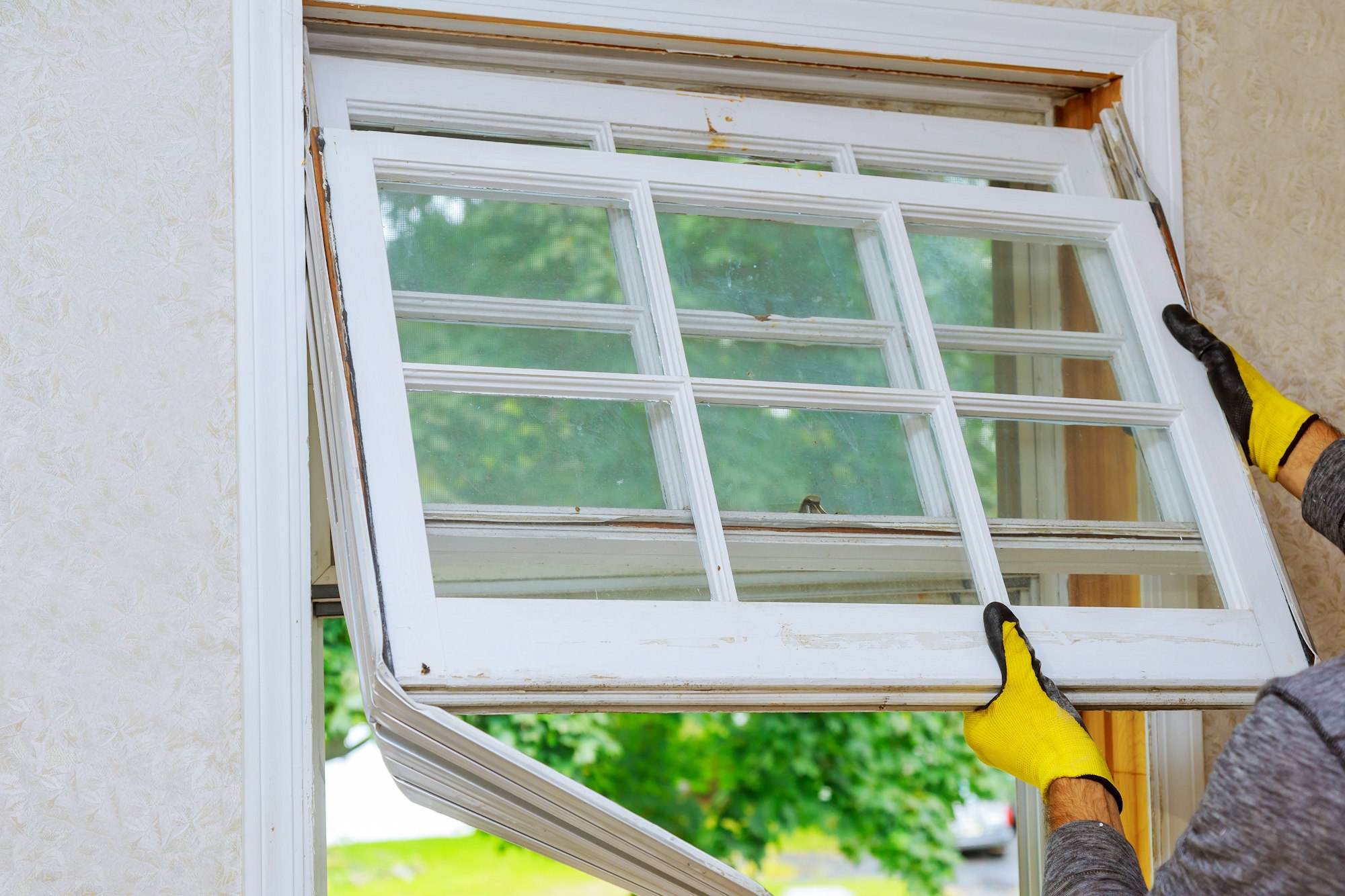 Worker hand removing old window replacing the old wooden window,